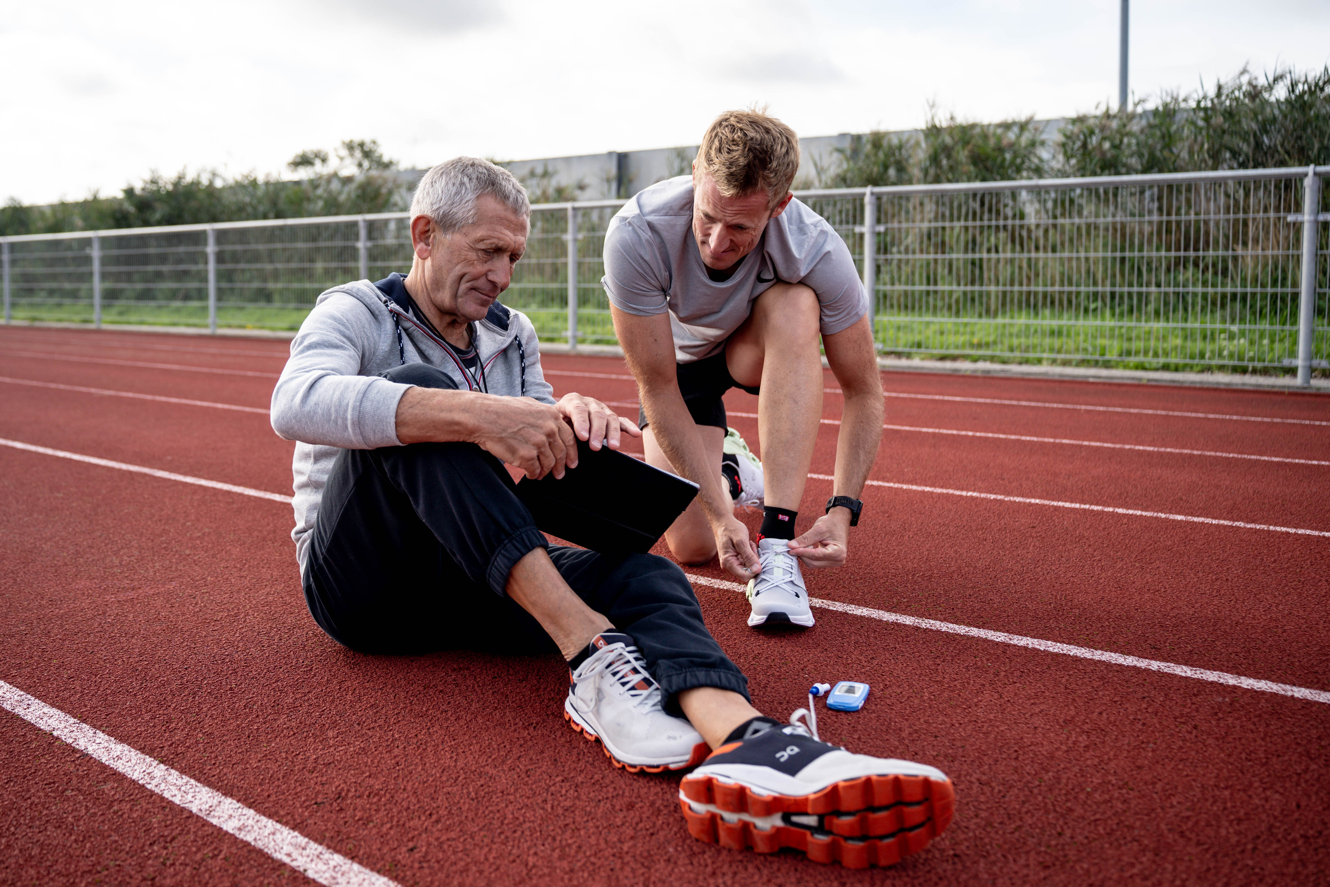 Coach en atleet op de atletiekpiste